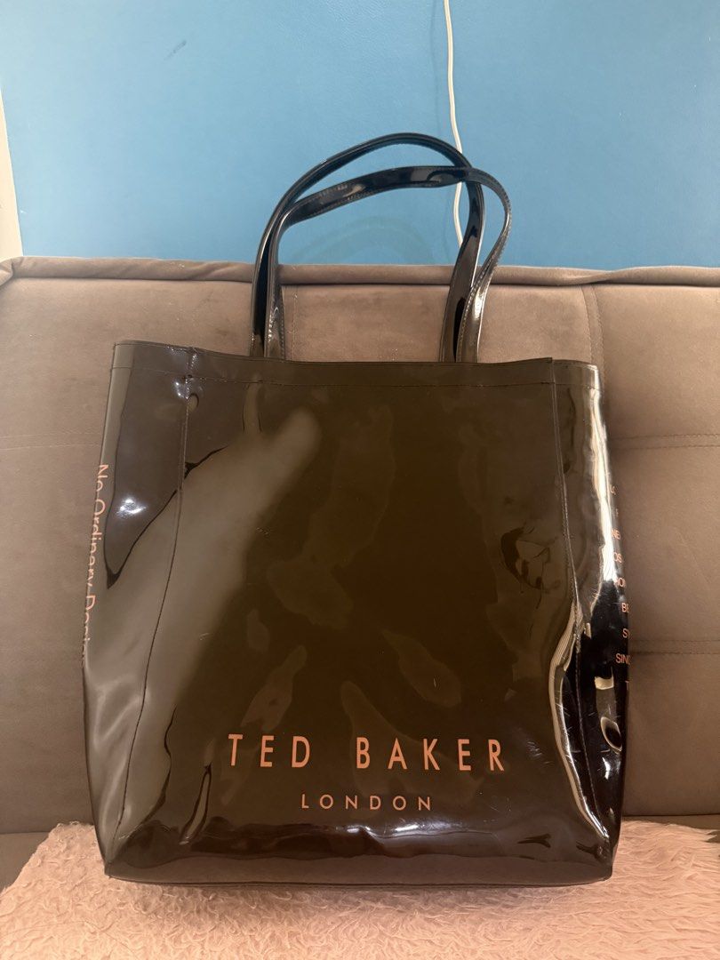 Ted Baker Black Patent Tote Bag with Bow (Category: Tote Bags) located in Malolos. Submitted by gb_21895 (Listing ID 1465951171, Image 3). Description: - Brand: Ted Baker London - Material/Finish: Black patent finish with rose gold hardware - Design Details: Statement bow on front, bold branding at the bottom, and global city names on side gussets - Storage: Roomy main compartment with an interior zip pocket on the back wall - Straps: Double shou