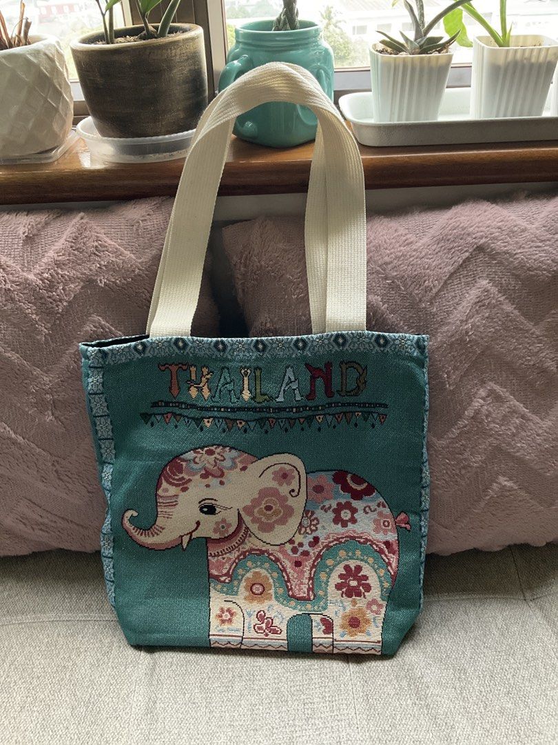 Thailand elephant patterned canvas tote bag (Category: Tote Bags) located in Quezon City. Submitted by freshspaces (Listing ID 1465776113, Image 1). Description: - Color: Teal green with cream shoulder straps - Design: Large, colorful embroidered elephant graphic with 'THAILAND' lettering - Condition: Excellent, clean, gently used (souvenir from a trip) - Features: Spacious interior, durable canvas material - Perfect for: Daily errands, carrying 