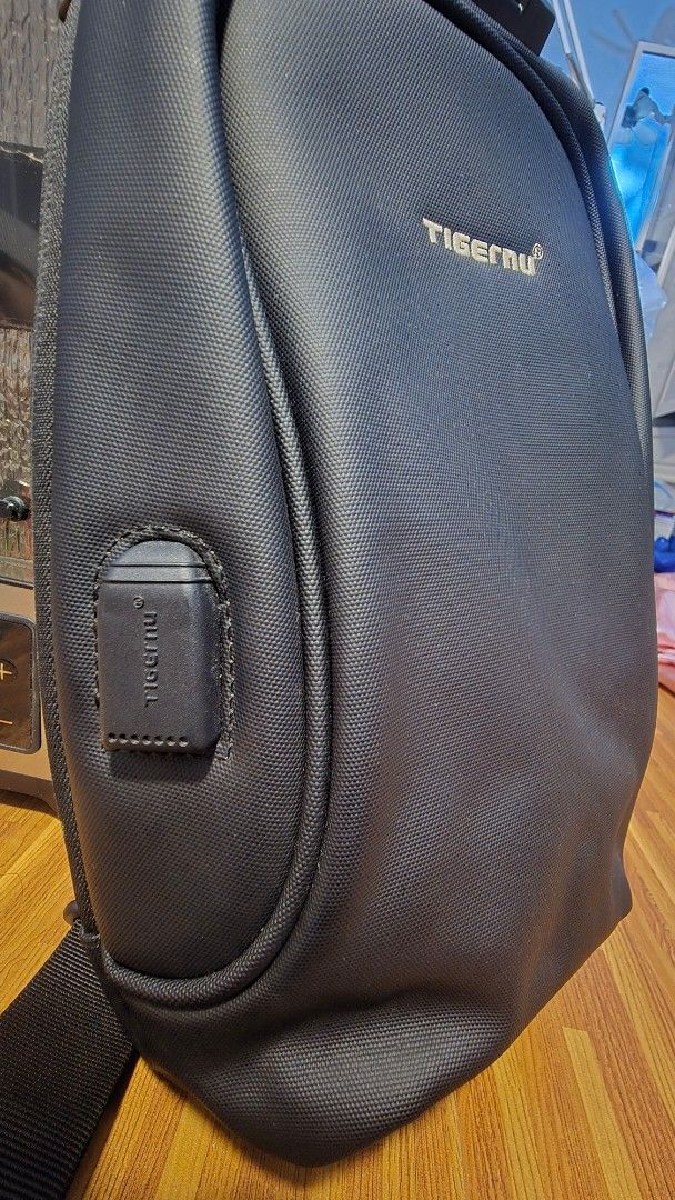 Tigernu Messenger Sling Shoulder Bag (Category: Sling Bags) located in Caloocan City. Submitted by marces (Listing ID 1465856239, Image 3). Description: - Brand: Tigernu - Color: Classic Black - Built-in USB charging port with internal cable included - Integrated anti-theft TSA combination lock for main zipper - Spacious main compartment with multiple organizational slip pockets - Comfortable adjustable padded shoulder strap - Durable splash-proo