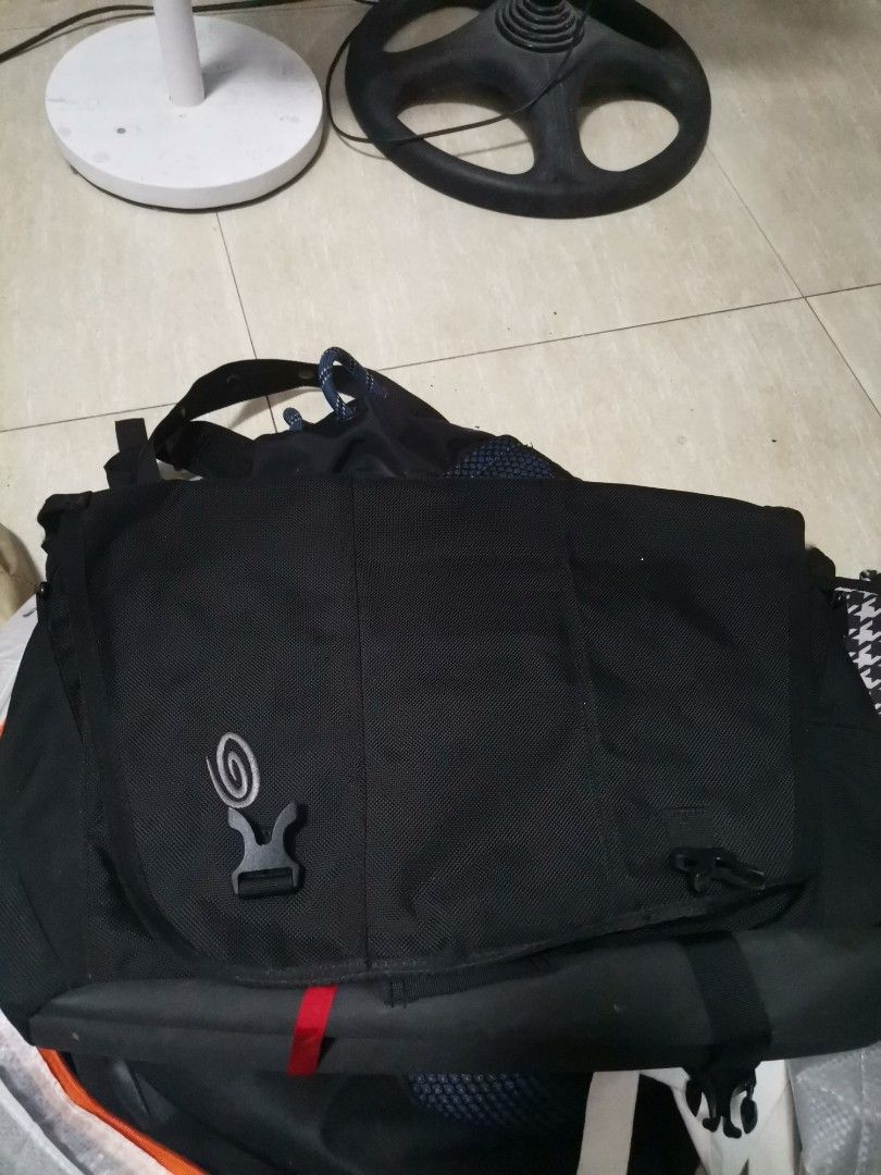 Timbuk2 Black Messenger Bag with Interior Pockets (Category: Sling Bags) located in Makati City. Submitted by kookybearsstuff (Listing ID 1465824522, Image 1). Description: - Brand: Timbuk2 messenger bag - Color: Classic black exterior with grey interior lining - Storage: Multiple interior compartments, zipper pockets, mesh slots, and a secure key strap - Closure: Flap closure with heavy-duty buckle - Capacity: Spacious enough for daily commute g