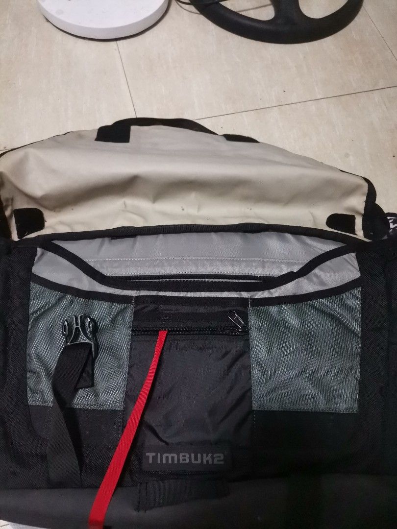 Timbuk2 Black Messenger Bag with Interior Pockets (Category: Sling Bags) located in Makati City. Submitted by kookybearsstuff (Listing ID 1465824522, Image 2). Description: - Brand: Timbuk2 messenger bag - Color: Classic black exterior with grey interior lining - Storage: Multiple interior compartments, zipper pockets, mesh slots, and a secure key strap - Closure: Flap closure with heavy-duty buckle - Capacity: Spacious enough for daily commute g