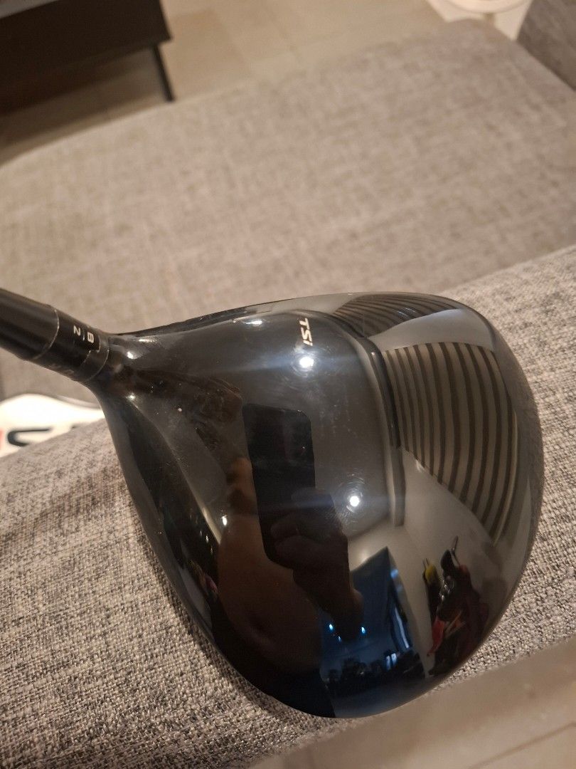 Titleist TSi2 Driver (Category: Golf) located in Manila. Submitted by wongkarwai77 (Listing ID 1465915164, Image 3). Description: - Authentic Titleist TSi2 Driver with matching white and black headcover - Shaft: Diamana TM 55 S graphite shaft with standard golf grip - Adjustability: Adjustable hosel settings near the adapter for custom ball flight - Condition: Clubhead shows normal ball marks on the face and minor swirling on the crown from stand