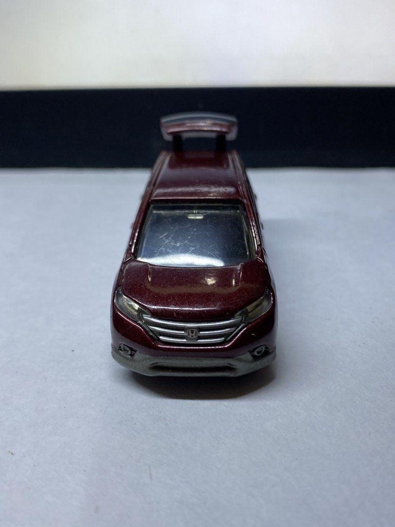 Tomica Honda CR-V Diecast (Category: Vehicle & Diecast Models) located in Paranaque City. Submitted by marcobotin (Listing ID 1465945398, Image 2). Description: - Brand: Tomica - Model: Honda CR-V in metallic maroon - Features: Opening rear trunk showing cargo area, detailed silver grille, headlights, and wheels - Mobility: Smooth rolling wheels - Condition: Paint chipping near the rear bumper and left rear light area.