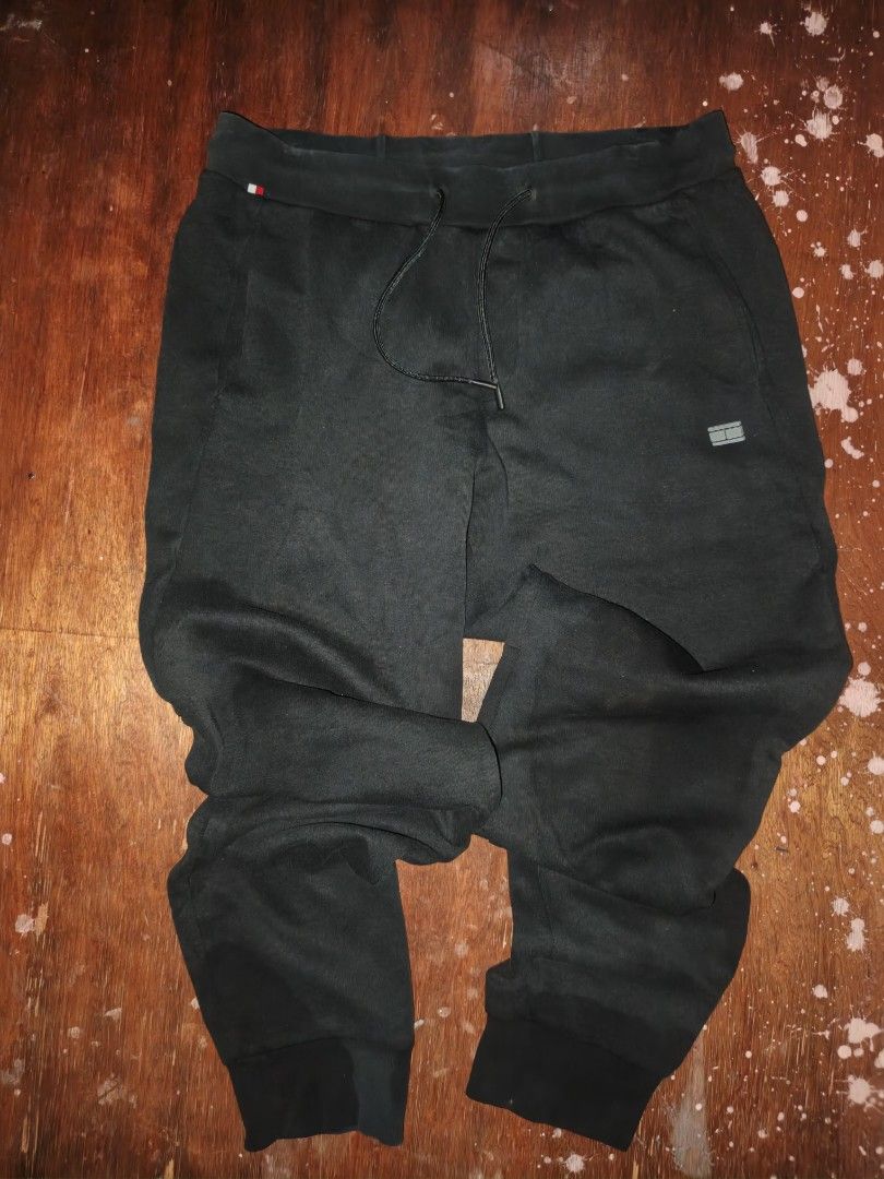 Tommy Hilfiger Black Sweatpants Joggers Medium (Category: Joggers) located in Manila. Submitted by esteemed_shop (Listing ID 1465896772, Image 1). Description: Tommy Hilfiger black sweatpants. Men's medium size, 175/84B. Elastic waistband with a drawstring. Ribbed cuffs at the ankles. Small Tommy Hilfiger flag logo embroidery near the pocket. Pocket on the back right side with flag accent. Inside tag shows code MW0MW22924. Clean condition, no tea