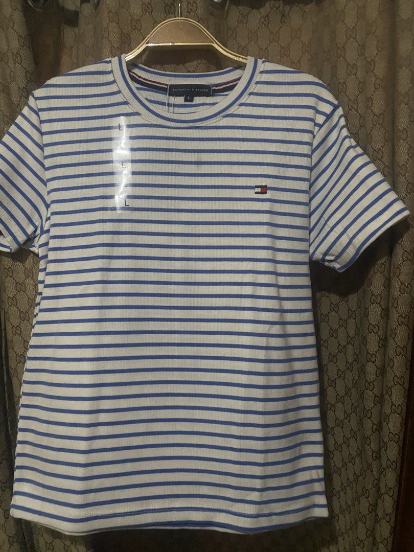 Tommy Hilfiger Striped T-Shirt (Category: Shirts) located in Cavite. Submitted by Abril_07 (Listing ID 1448926945, Image 1). Description: - Classic blue and white striped t-shirt - Brand: Tommy Hilfiger - Features ribbed texture - Small logo detail on the chest - Versatile staple piece for any wardrobe.