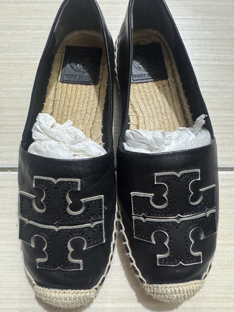 Tory Burch Black Leather Logo Espadrilles (Category: Flats & Sandals) located in Manila. Submitted by gulia21 (Listing ID 1465923456, Image 3). Description: - Brand: Tory Burch - Material: Premium black leather upper with jute braided sole - Design: Slip-on espadrilles featuring a large silver-toned cutout logo - Interior: Comfortable leather inner sole with stamped brand logo - Condition: Excellent, structured shape carefully maintained with pap