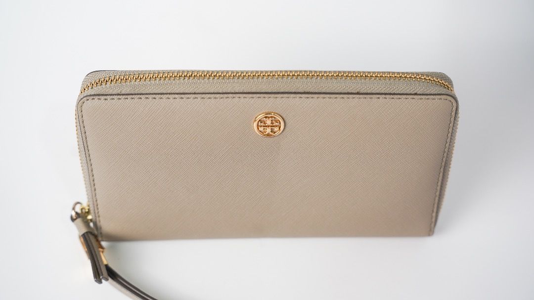 Tory Burch Saffiano Leather Wristlet Wallet Grey (Category: Luxury Bags & Wallets) located in Pasig City. Submitted by laagn.ph (Listing ID 1465764290, Image 2). Description: - Brand: Tory Burch - Material: Premium Saffiano leather in versatile grey - Hardware: Gold-tone with iconic front logo plaque - Features: Secure zip-around closure and matching detachable wrist strap - Interior: Standard size with plenty of slots for cards and cash - Condit
