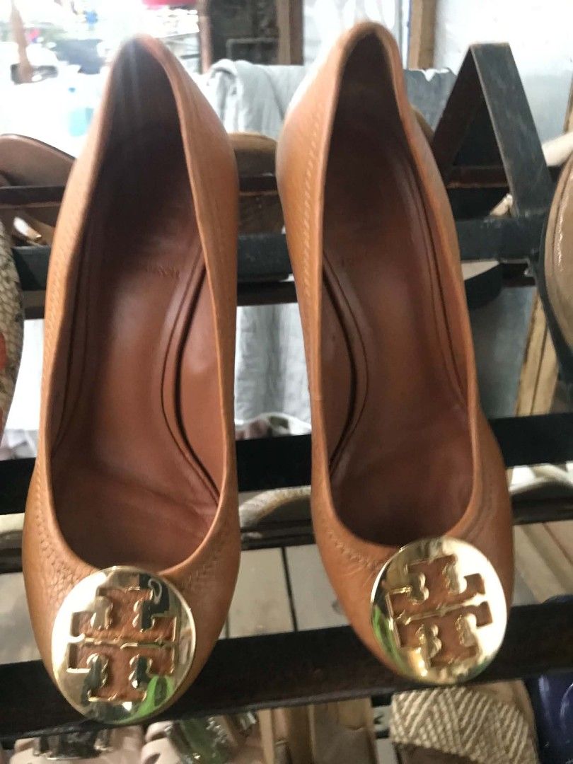 Tory Burch Tan Leather Wedge Heels Size 5M (Category: Wedges) located in Midsayap. Submitted by purse_gedo (Listing ID 1465892436, Image 1). Description: - Brand: Tory Burch - Style: Tan leather wedge heels with slip-on design - Size: 5M (indicated on inner stamp) - Material: Genuine leather upper and lining, wooden wedge heel - Details: Classic round toe and iconic gold-tone metal logo medallion on the front - Origin: Made in Brazil - Condition: