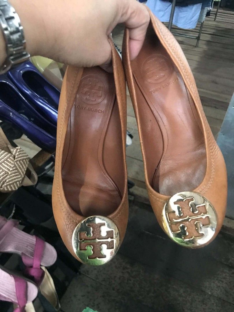 Tory Burch Tan Leather Wedge Heels Size 5M (Category: Wedges) located in Midsayap. Submitted by purse_gedo (Listing ID 1465892436, Image 2). Description: - Brand: Tory Burch - Style: Tan leather wedge heels with slip-on design - Size: 5M (indicated on inner stamp) - Material: Genuine leather upper and lining, wooden wedge heel - Details: Classic round toe and iconic gold-tone metal logo medallion on the front - Origin: Made in Brazil - Condition: