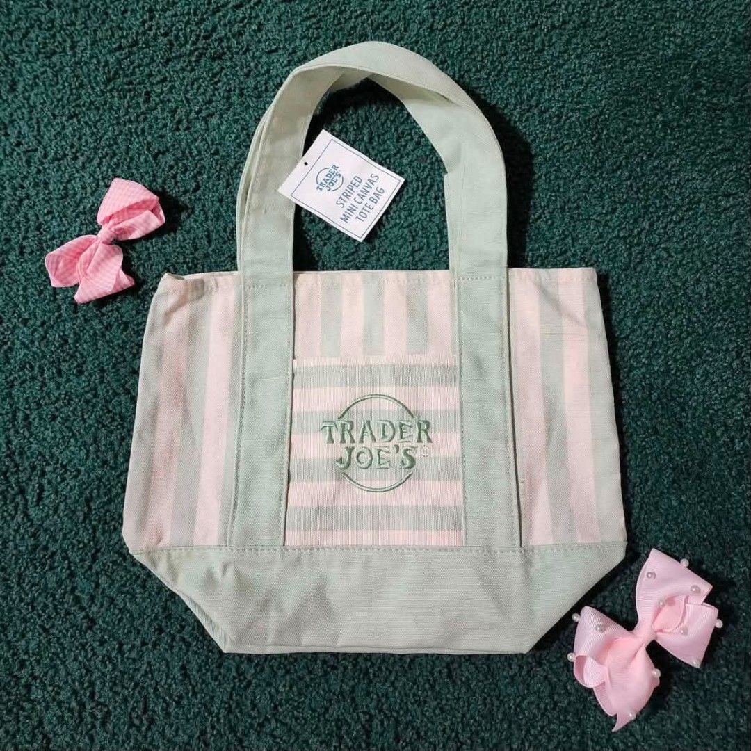 Trader Joe's Striped Mini Canvas Tote Bag (Category: Tote Bags) located in Manila. Submitted by marcialgherman1 (Listing ID 1465900345, Image 2). Description: - 100% Brand new with original store tags attached - Material: Durable heavy-duty cotton canvas - Design: Stylish pastel stripes with embroidered Trader Joe's logo on the front pocket - Features: Strong top carrying handles - Size: Compact and convenient for daily errands or lunch - Availab