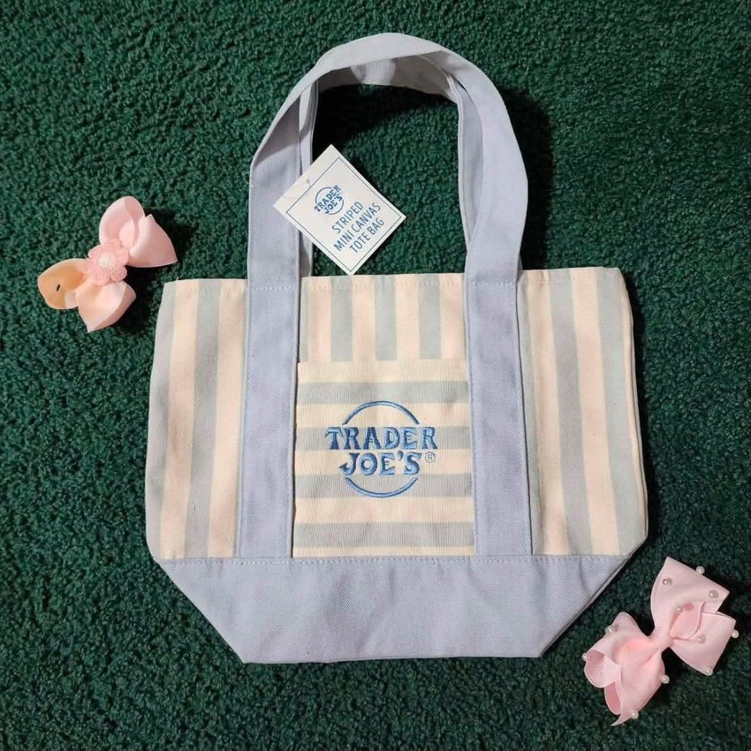 Trader Joe's Striped Mini Canvas Tote Bag (Category: Tote Bags) located in Manila. Submitted by marcialgherman1 (Listing ID 1465900345, Image 3). Description: - 100% Brand new with original store tags attached - Material: Durable heavy-duty cotton canvas - Design: Stylish pastel stripes with embroidered Trader Joe's logo on the front pocket - Features: Strong top carrying handles - Size: Compact and convenient for daily errands or lunch - Availab