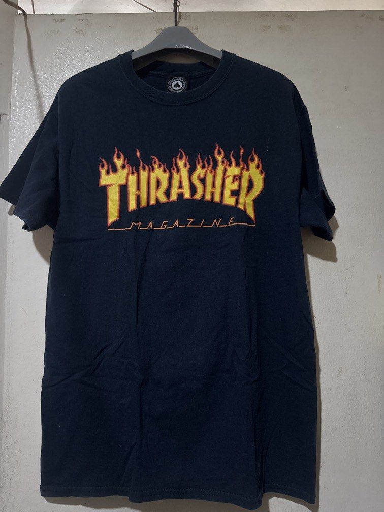 Trasher Tee (Category: Tshirts & Polo Shirts ) located in Danao, Cebu. Submitted by welvirinec29053 (Listing ID 1465782043, Image 1). Description: This is a classic dark blue Thrasher Flame T-Shirt featuring the iconic yellow and red flame graphic across the chest. size M dimes 20x28 color 10/10 made in dominican republic.