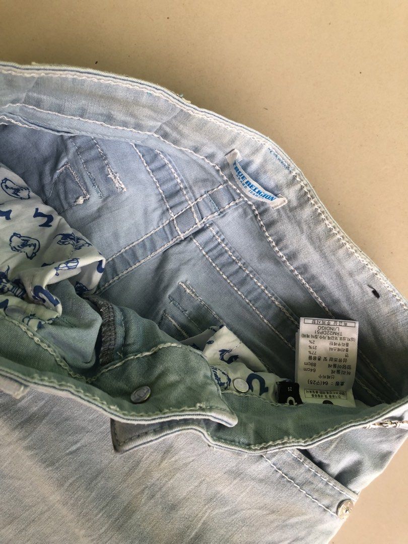 True Religion Light Wash Denim Jeans (Category: Jeans) located in Cagayan de Oro. Submitted by leklekthrift (Listing ID 1465889449, Image 2). Description: - Brand: True Religion - Style: Light wash faded denim with a flared leg cut - Size: 25 (Cotton & polyester blend) - Pockets: Front and back pockets with secure flap button closures - Details: Signature horseshoe stitching on back pockets, classic brand logo patch, and custom inner lining - Con
