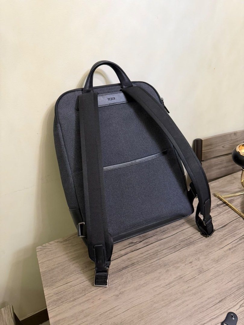 TUMI Harrison Grey Backpack (Category: Backpacks) located in Manila. Submitted by jonkakkee (Listing ID 1465846640, Image 2). Description: - Authentic Tumi backpack in dark grey textured fabric - Premium black leather trim on the bottom and top handle - Secure double zip main compartment & front zip pocket with logo plate - Includes side luggage tag & Tumi Tracer metal plate with barcode - Comfortable, padded, and adjustable back straps - Clean i