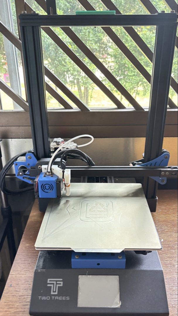 Two Trees 3D Printer (Category: Printers, Scanners & Copiers) located in Singapore. Submitted by komalone (Listing ID 1465825372, Image 1). Description: - Brand/Model: Two Trees 3D Printer - Condition: Used, powers up fine (print bed has residue from previous prints) - Key Features: Blue accents, standard frame setup with PTFE tubing - Build Plate: Energetic 3D build plate - Interface: Digital display panel on the front base -(Note * have issue o