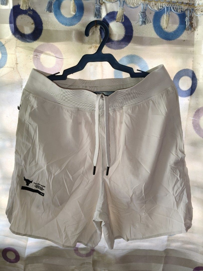 Under Armour Project Rock Workout Shorts White Small (Category: Shorts) located in Compostela. Submitted by johnwilz1144610 (Listing ID 1465765101, Image 1). Description: - Brand: Under Armour Project Rock - Color: white/Cream - Size: Small(29-30waist) - Material: Lightweight performance fabric - Waistband: Adjustable with drawstring - Storage: Secure zippered back pocket and zippered side pockets - Details: Project Rock bull logo and 'Built for 