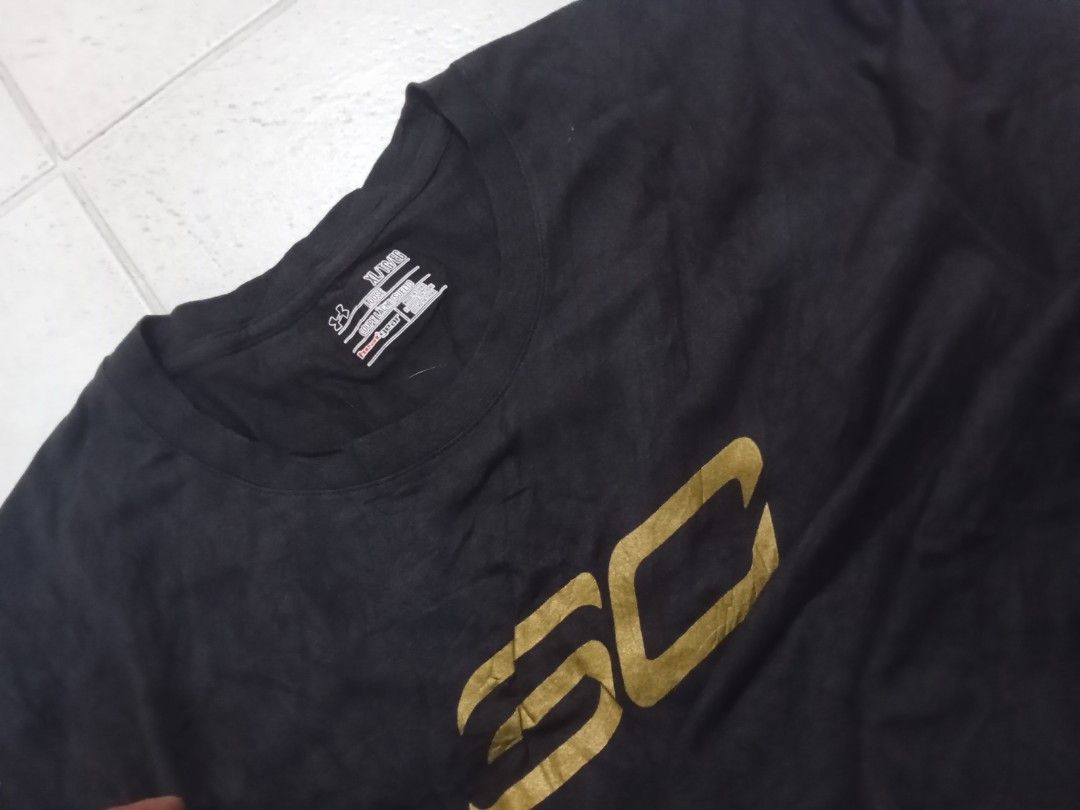 Under Armour Stephen Curry Back 2 Back MVP T-Shirt (Category: Tshirts & Polo Shirts ) located in Manila. Submitted by kitkathrift (Listing ID 1465868416, Image 2). Description: - Brand: Under Armour x Stephen Curry - Design: Back 2 Back MVP graphic with metallic gold SC logo and two stars - Size: XL (Loose Fit) - Color: Black - Details: Sleeve branding and jock tag hem patch - Condition: Good, neck tag intact.