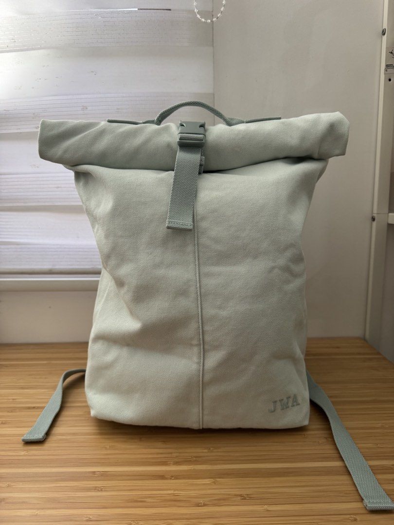 Uniqlo JWA Canvas Backpack (Category: Backpacks) located in Makati City. Submitted by the.archives (Listing ID 1465856744, Image 1). Description: - Color: light teal - Material: durable/ thick canvas - Closure: Buckle securing the rolled top - Comfort: Padded shoulder straps and top carry handle - Detail: Embroidered initials 'JWA, with small pocket inside, with secret zipper on the side for easy access - Condition: Clean fabric with minimal wear