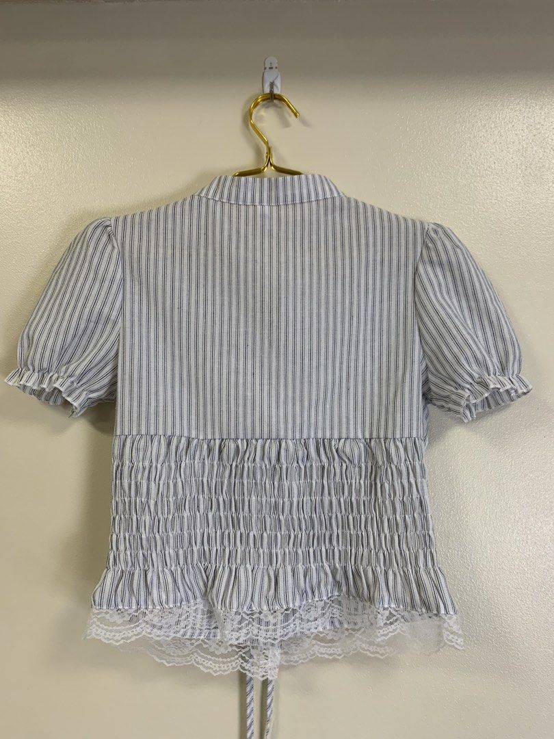 Vietnam top (Category: Blouses) located in Davao. Submitted by 2ndbase.dvo.ii (Listing ID 1465854868, Image 3). Description: - Style: Blue and white pinstripe short sleeve blouse - Size: Medium (tag on collar) - Details: Mandarin collar, front button closure with decorative ties, puff sleeves with ruffled cuffs - Fit: Smocked elastic back panel for extra stretch and comfort - Accent: Lovely white lace hem detailing along the bottom - Condition: E