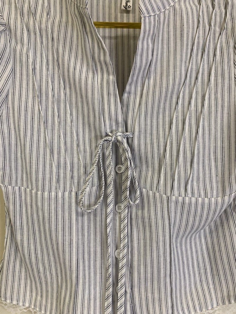 Vietnam top (Category: Blouses) located in Davao. Submitted by 2ndbase.dvo.ii (Listing ID 1465854868, Image 2). Description: - Style: Blue and white pinstripe short sleeve blouse - Size: Medium (tag on collar) - Details: Mandarin collar, front button closure with decorative ties, puff sleeves with ruffled cuffs - Fit: Smocked elastic back panel for extra stretch and comfort - Accent: Lovely white lace hem detailing along the bottom - Condition: E