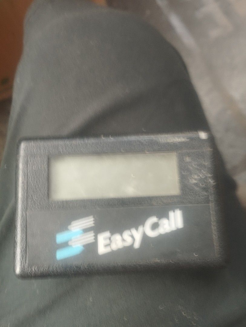 Vintage Easy Call Pager Device (Category: Vintage Collectibles) located in Mandaluyong City. Submitted by LEATHERFACE (Listing ID 1465769884, Image 1). Description: - Item: Vintage Black Easy Call Pager Unit - Style: Classic retro pocket-sized telecommunication gadget with digital screen - Condition: Collectible tech item with minor dust and surface wear from storage - Note: Battery door and interior condition not shown.