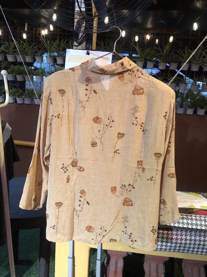Vintage Floral Print Beige Button-Up Blouse (Category: Blouses) located in Cauayan City . Submitted by wholly.craaaft (Listing ID 1465873519, Image 3). Description: - Style: Retro button-up blouse with all-over brown floral and botanical print - Color: Beige base with brown print - Fit: Regular fit, easy to pair with skirts or pants - Details: Long sleeves, pointed collar, front button closure - Fabric: Lightweight and textured material - Conditi