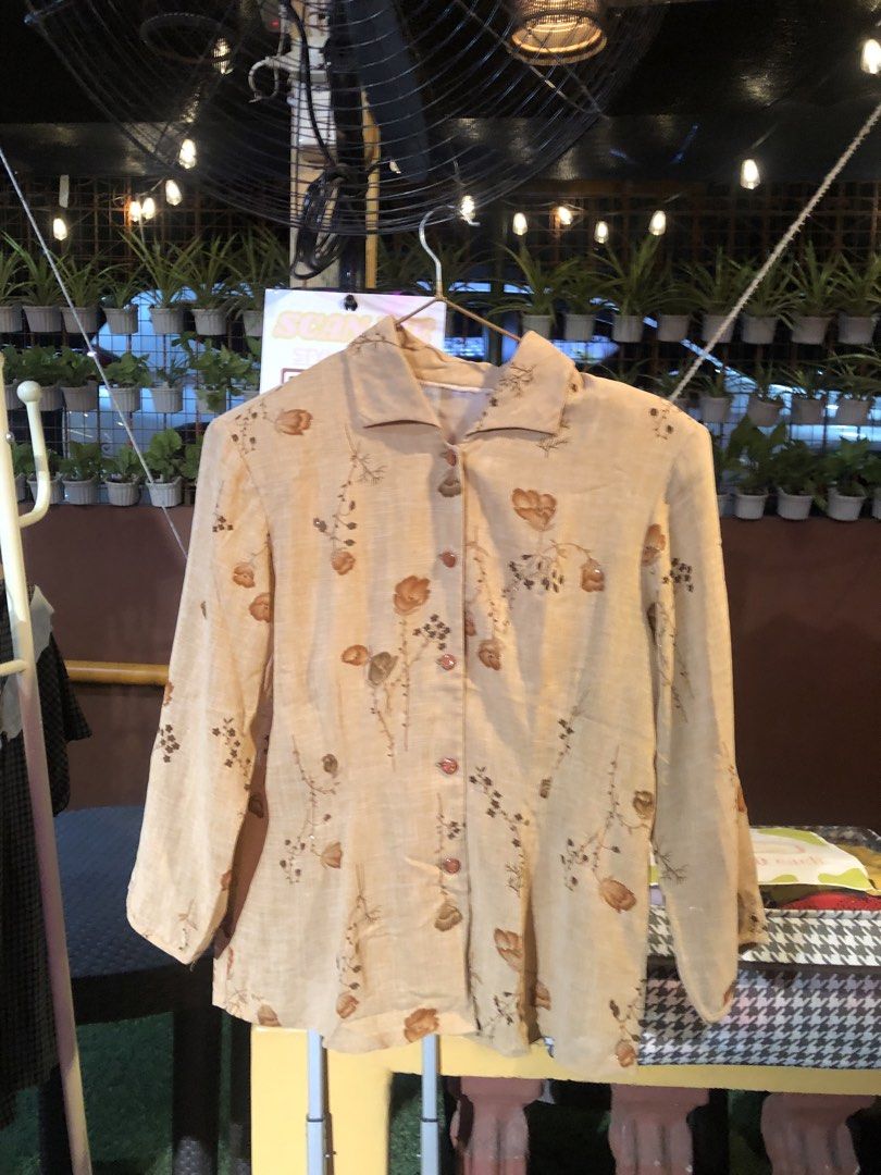 Vintage Floral Print Beige Button-Up Blouse (Category: Blouses) located in Cauayan City . Submitted by wholly.craaaft (Listing ID 1465873519, Image 1). Description: - Style: Retro button-up blouse with all-over brown floral and botanical print - Color: Beige base with brown print - Fit: Regular fit, easy to pair with skirts or pants - Details: Long sleeves, pointed collar, front button closure - Fabric: Lightweight and textured material - Conditi
