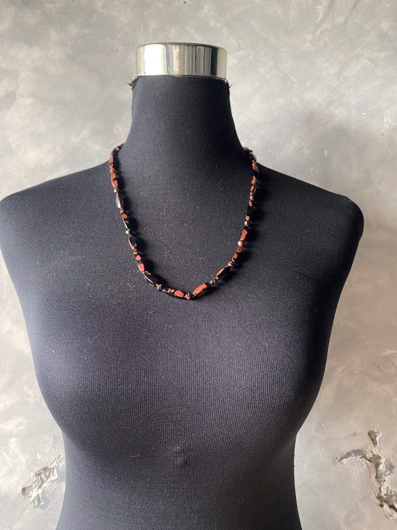 Vintage obsidian necklace (Category: Other Accessories) located in Cebu City. Submitted by janb85 (Listing ID 1465853848, Image 1). Description: A vintage beaded tokachi stone (obsidian) necklace featuring polished, elongated barrel-shaped and round gemstone beads in contrasting shades of terracotta red and deep black, separated by small golden seed beads and finished with a patterned silver-tone clasp..