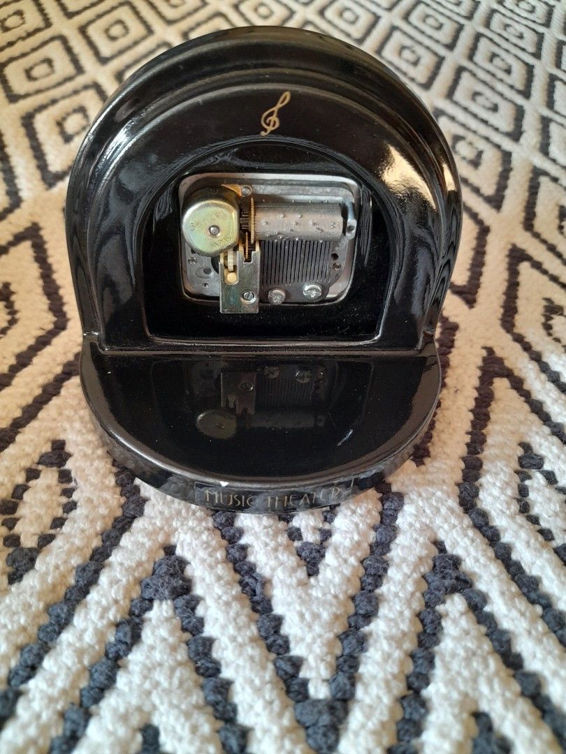Vintage Sankyo Music Box (Category: Other Home Decor) located in Bocaue. Submitted by marajapansurplus (Listing ID 1465843074, Image 3). Description: - Vintage music theater musical box - Features a fascinating visible wind-up mechanism inside - Charming music note symbol printed on the side - Classic gold-toned winding key on the back with Japanese text label - Supported by a sturdy white half-circle base at the bottom.