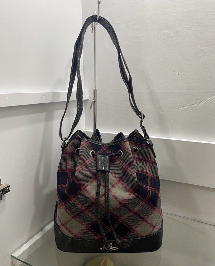 Vivienne Westwood Bag (Category: Luxury Bags & Wallets) located in Makati City. Submitted by the.archives (Listing ID 1465820813, Image 2). Description: - Brand: Vivienne Westwood - Style: Bucket bag in classic grey and red tartan plaid - Material/Trim: Premium black leather trim - Hardware: Silver-toned metal hardware, grommets, and protective bottom feet with engraved orb motif - Closure: Drawstring closure - Details: Iconic metal orb logo badg