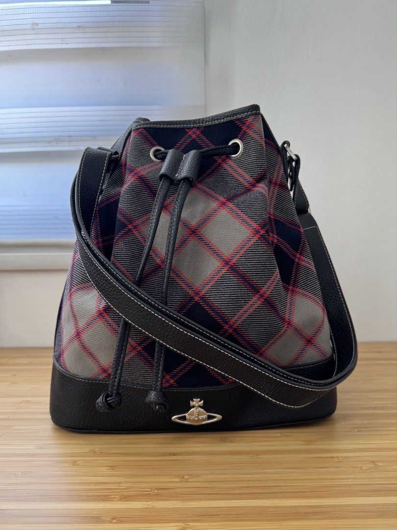 Vivienne Westwood Bag (Category: Luxury Bags & Wallets) located in Makati City. Submitted by the.archives (Listing ID 1465820813, Image 1). Description: - Brand: Vivienne Westwood - Style: Bucket bag in classic grey and red tartan plaid - Material/Trim: Premium black leather trim - Hardware: Silver-toned metal hardware, grommets, and protective bottom feet with engraved orb motif - Closure: Drawstring closure - Details: Iconic metal orb logo badg