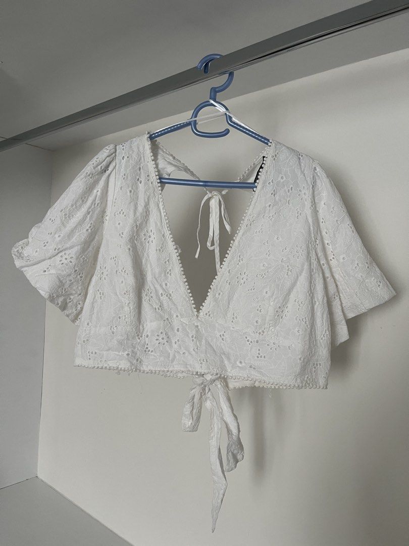 White Eyelet Crop Top Open Back Tie Front (Category: Sleeveless) located in Quezon City. Submitted by cooperminie (Listing ID 1465810853, Image 1). Description: - Color: White with all-over floral embroidery - Style: Crop top with trendy puff sleeves - Neckline: Deep plunge bordered with tiny pom poms - Back: Open back design with dual string ties and bottom knot - Fabric: Lightweight and breathable - Condition: Has some loose threads but unnotic