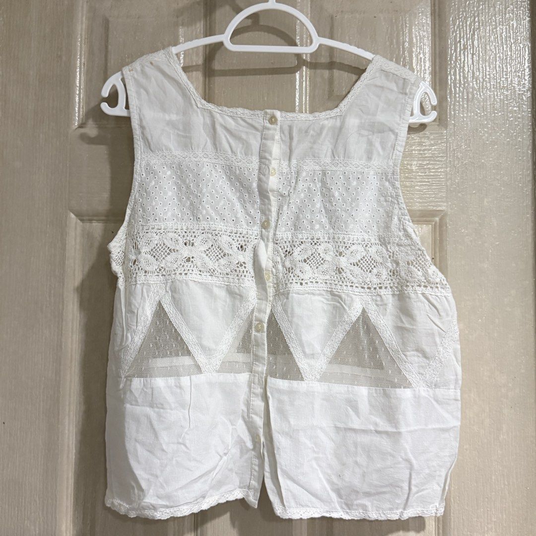 White lace sleeveless button-back top (Category: Sleeveless) located in Makati City. Submitted by julyco. (Listing ID 1465813847, Image 2). Description: - Color: White - Style: Sleeveless cropped top with square neckline - Details: Mixed texture eyelet lace and sheer dotted mesh triangle panels - Closure: Back button-down closure with small round buttons - Material: Lightweight, great for warm weather layering or beach cover up.