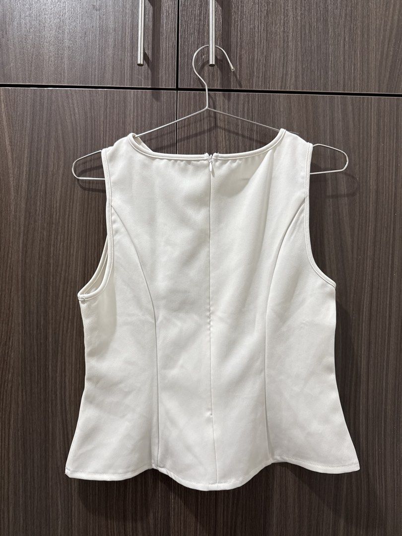 White sleeveless peplum top with back zip (Category: Sleeveless) located in Pasig City. Submitted by rchsh (Listing ID 1465824783, Image 2). Description: - Color: Solid off white - Style: Sleeveless top with a flared peplum hem - Fit: Tailored with structured panels front and back - Details: Scoop neckline and visible upper back zipper closure - Versatility: Clean, minimalist design ideal for casual outings or office wear.