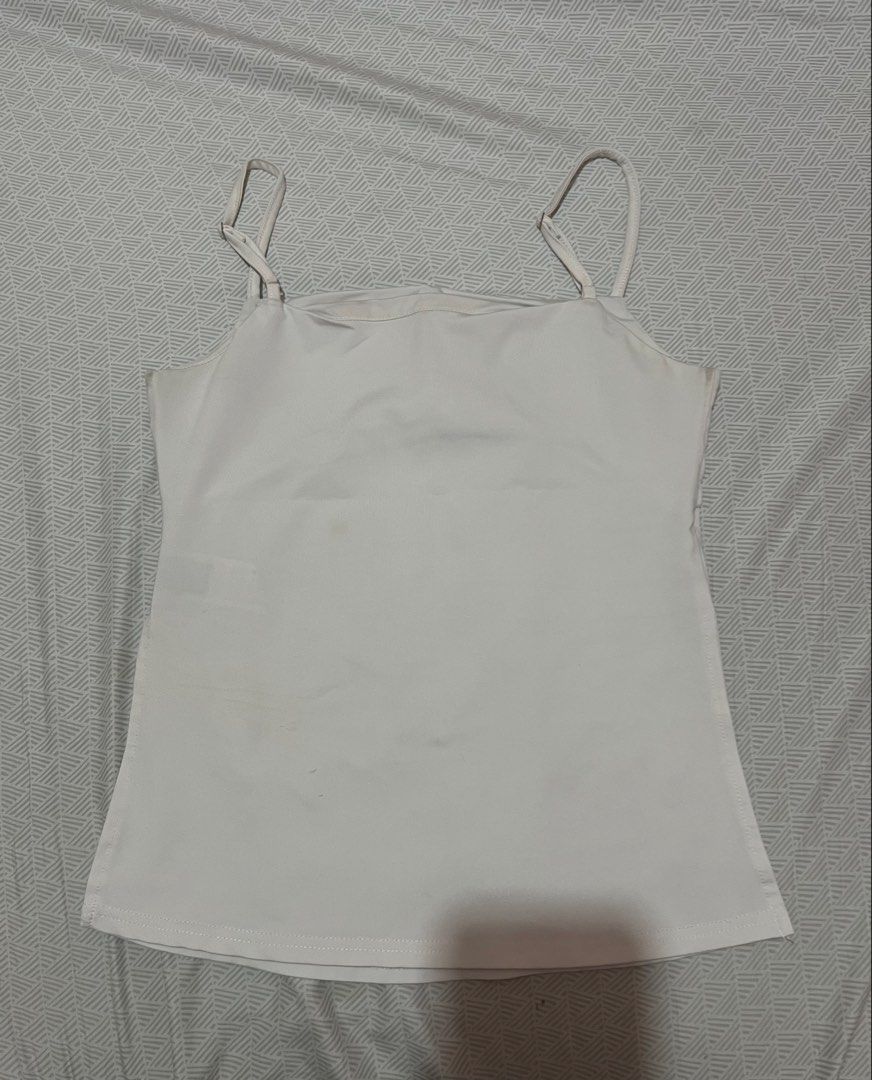 White Spaghetti Strap Camisole Top (Category: Sleeveless) located in Manila. Submitted by kaceylgt (Listing ID 1465923840, Image 2). Description: - Color: White - Neckline: Straight - Straps: Adjustable thin straps - Fit: Body-hugging, smooth fabric - Versatility: Perfect for layering or standalone wear - Style: A must-have wardrobe essential.