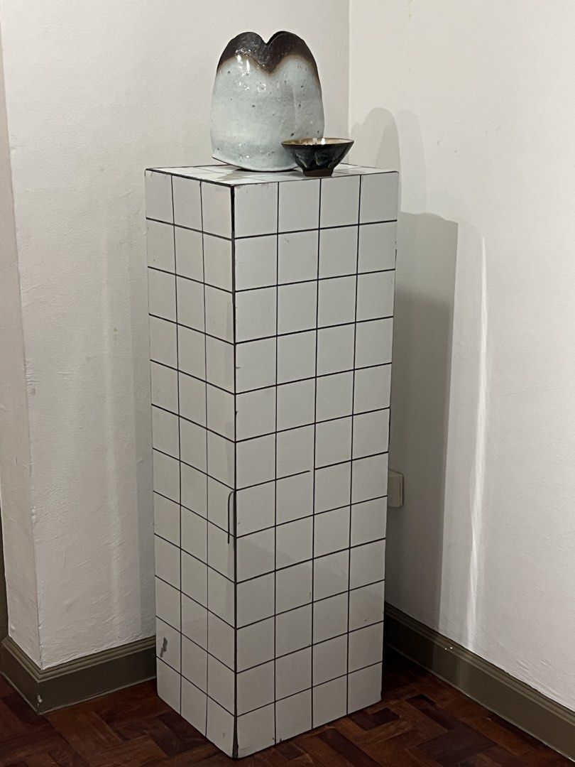 White tiled pedestal (Category: Vases & Decorative Bowls) located in Quezon City. Submitted by raccoonfur (Listing ID 1465871571, Image 3). Description: Plinth made of APC material to mimic bathroom tiles. A modernist interpretation of Jean-Pierre Reynaud’s installation. Stable with adequate weight. Great for displaying your contemporary art pieces. Has sticker shaving remains when used for a dystopian set design. Has that punk rock air to it. Wi