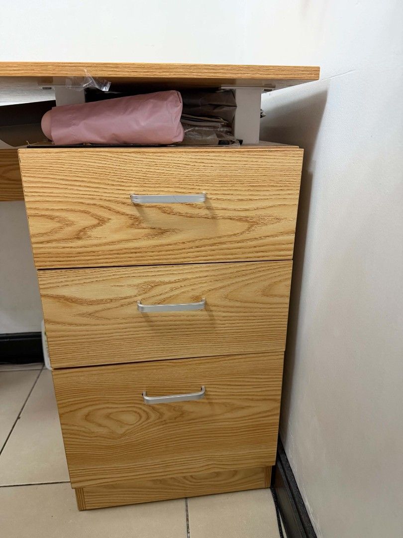 Wooden Study Desk with Attached 3-Drawer Cabinet (Category: Office Furniture & Fixtures) located in Makati City. Submitted by xxcassy (Listing ID 1465861478, Image 3). Description: - Type: Wooden study desk with white metal frame - Storage: Built-in 3-drawer cabinet underneath - Finish: Natural wood grain top and drawers - Dimensions: 110 × 54 × 74 cm (L × W × H) - Condition: Clean, sturdy, and ready for use - Ideal for: Work from home (WFH) setu