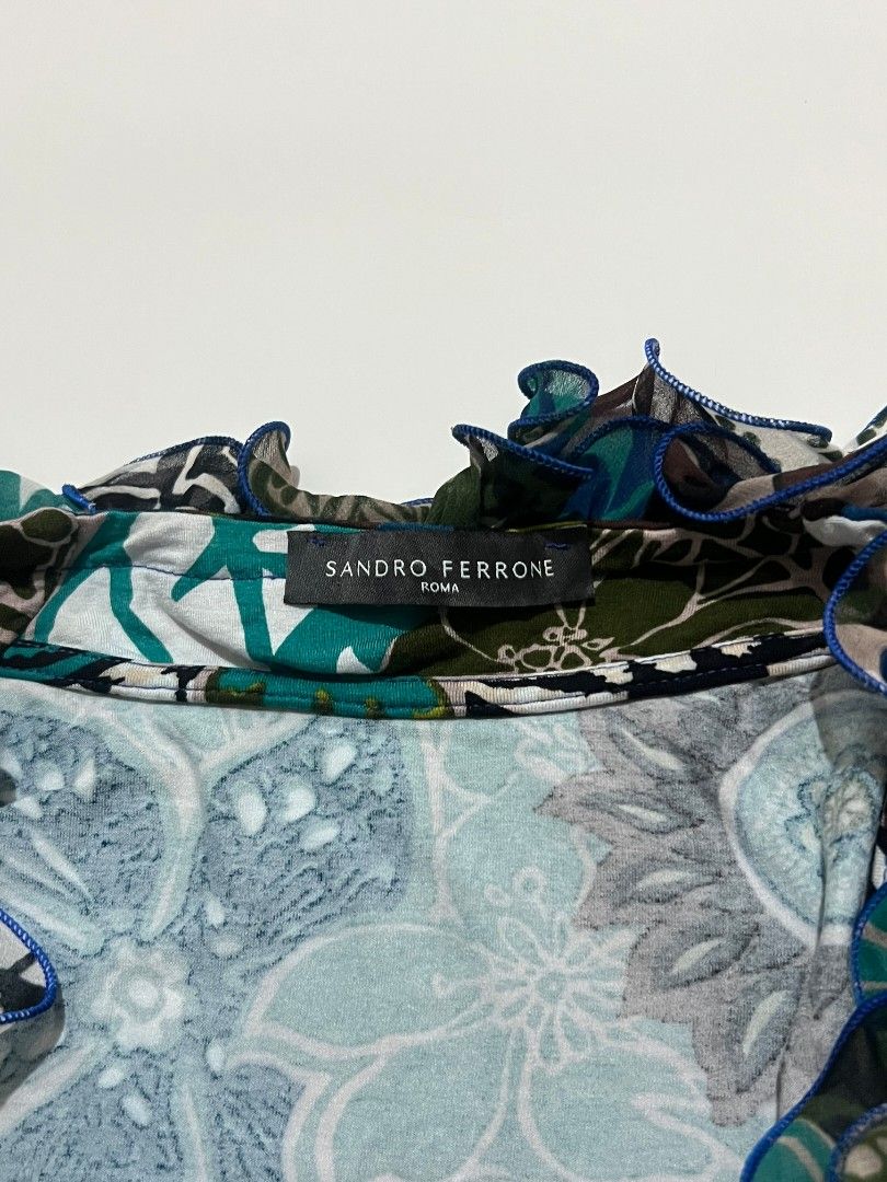 Y2k 2000s Sandro Ferrone Roma Floral Ruffle Top (Category: Sleeveless) located in Kidapawan. Submitted by rav.rose (Listing ID 1465942518, Image 2). Description: - Brand: Sandro Ferrone Roma - Design: Bold mixed floral pattern in blues, greens, and neutrals - Detail: Dramatic ruffled collar trimmed with chic blue piping - Cut: Sleeveless - Condition: Excellent, authentic fabric label intact - Style Tip: Great for pairing with slacks or skirts for