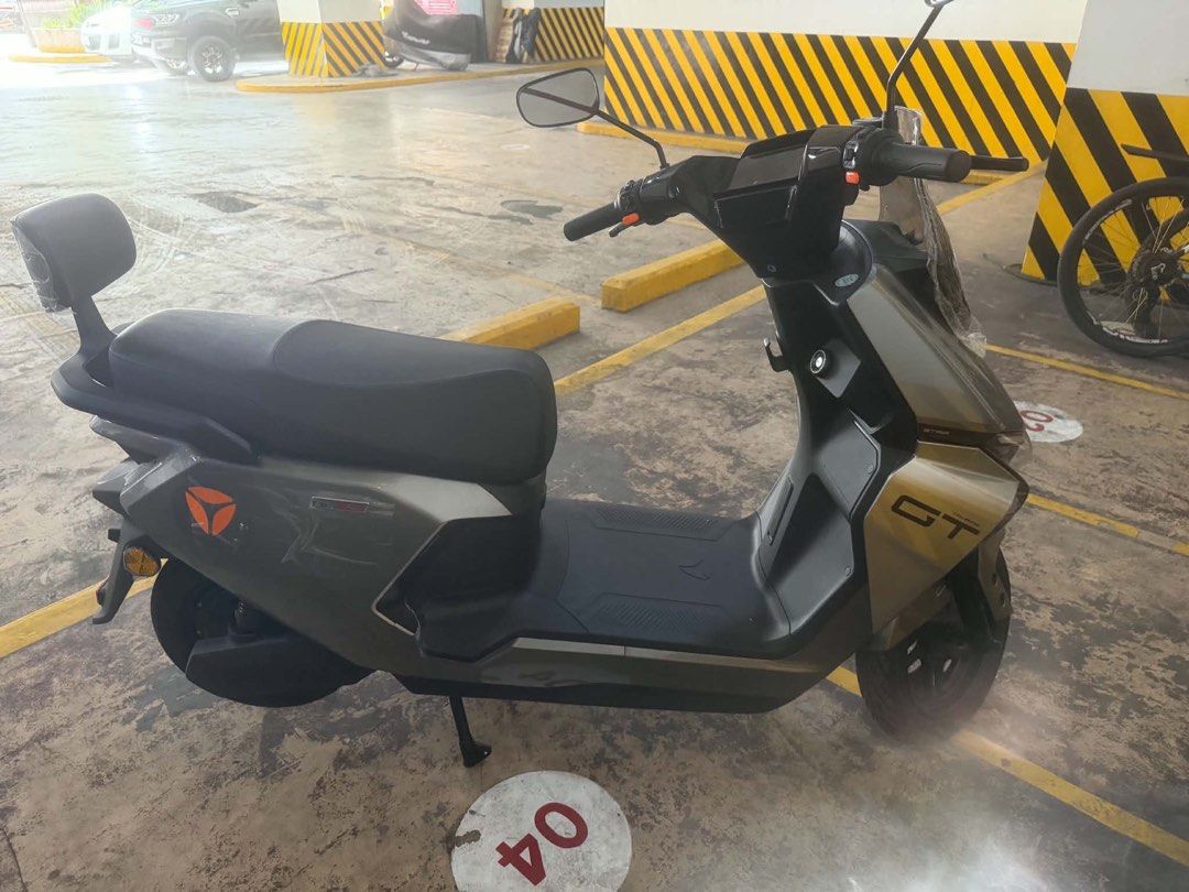 Yadea GT Touring Electric Scooter Grey (Category: Skates, Rollerblades & Scooters) located in Manila. Submitted by katrine_gervacio (Listing ID 1465874038, Image 3). Description: - Model: Yadea GT Touring Electric Scooter - Color: Sleek Grey with Orange accents - Condition: Like new / Barely used, protective plastic still on windscreen and rear backrest - Features: Clean body with zero scratches, black seat, floor mat, handlebars, and dual kickst