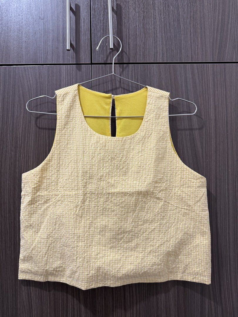Yellow gingham sleeveless crop top with button back (Category: Sleeveless) located in Pasig City. Submitted by rchsh (Listing ID 1465820928, Image 1). Description: - Color/Pattern: Yellow and white gingham - Style: Sleeveless crop top with rounded neckline - Details: Back button closure with keyhole cutout - Material: Lightweight textured cotton - Condition: Clean and ready to wear.