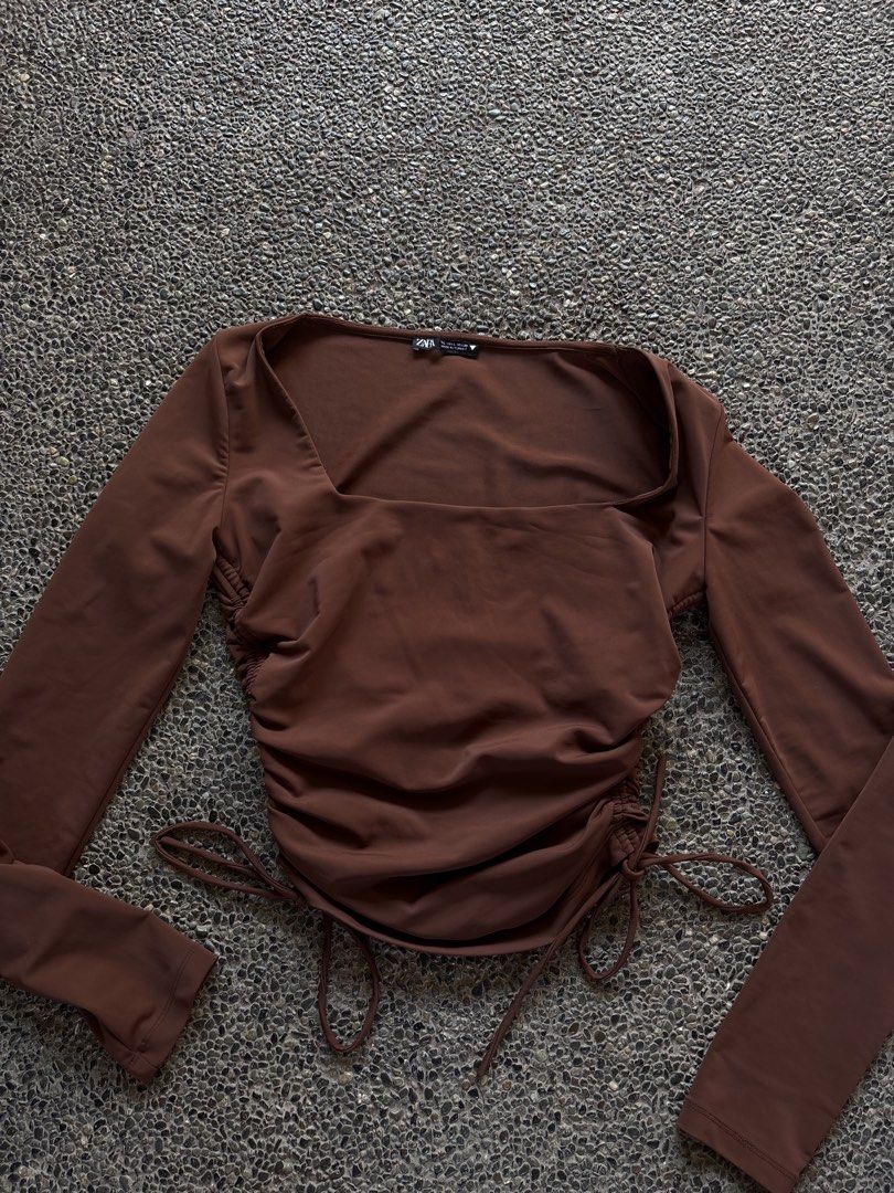 Zara Brown Ruched Long Sleeve Top (Category: Longsleeves) located in San Fernando. Submitted by gigikyla (Listing ID 1465923926, Image 2). Description: - Brand: Zara - Color: Brown - Style: Long sleeve with square neckline - Features: Adjustable side drawstrings for custom ruching and length - Material: Soft and stretchy fabric - Condition: Worn once, still in great shape.