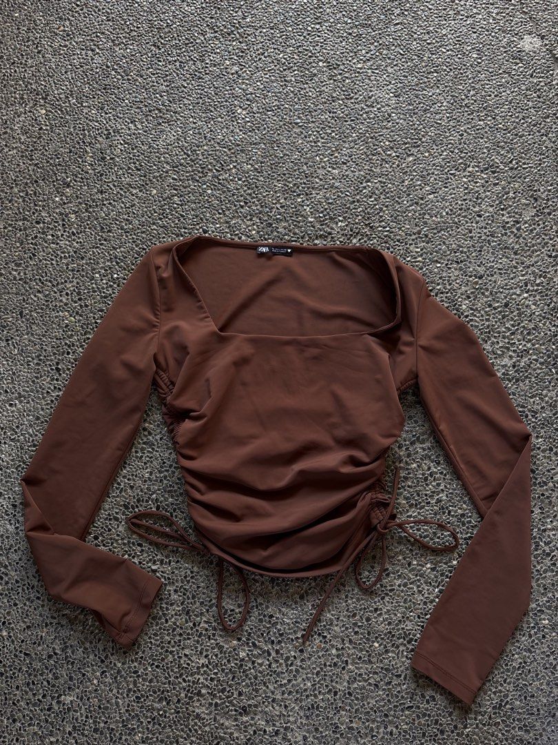 Zara Brown Ruched Long Sleeve Top (Category: Longsleeves) located in San Fernando. Submitted by gigikyla (Listing ID 1465923926, Image 1). Description: - Brand: Zara - Color: Brown - Style: Long sleeve with square neckline - Features: Adjustable side drawstrings for custom ruching and length - Material: Soft and stretchy fabric - Condition: Worn once, still in great shape.