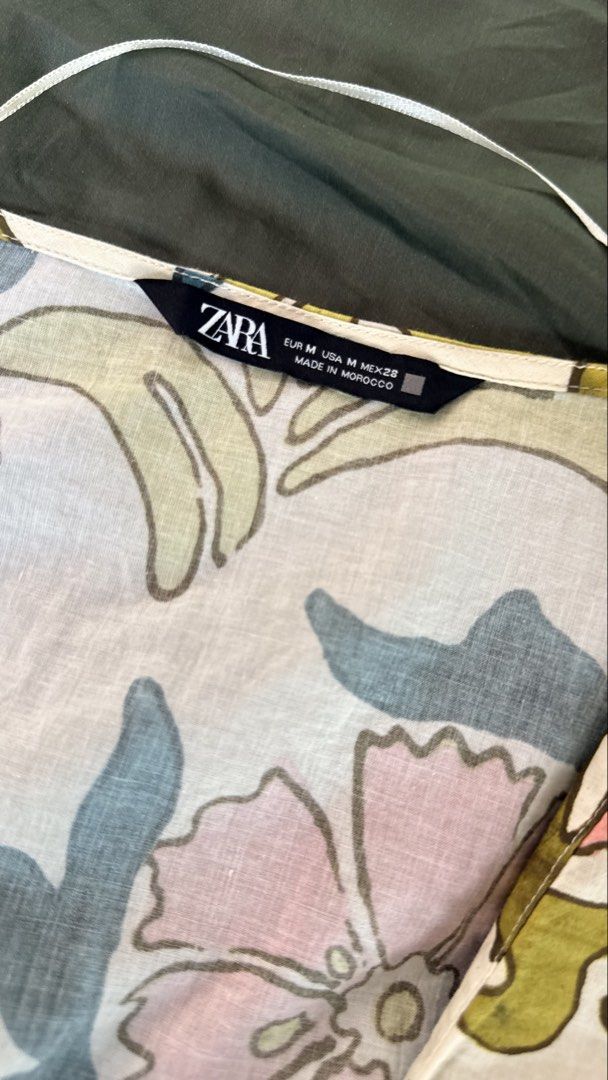 Zara Floral Print Blouse Size M (Category: Blouses) located in Batangas. Submitted by krieldre (Listing ID 1465777461, Image 3). Description: - Brand: Zara - Size: M (Made in Morocco) - Design: Colorful abstract floral pattern (pink, blue, yellow, green) - Details: V-neckline with hanging string, short sleeves, gathered waist hem - Material: Lightweight and breathable fabric - Condition: Excellent pre-loved condition (ready to wear).
