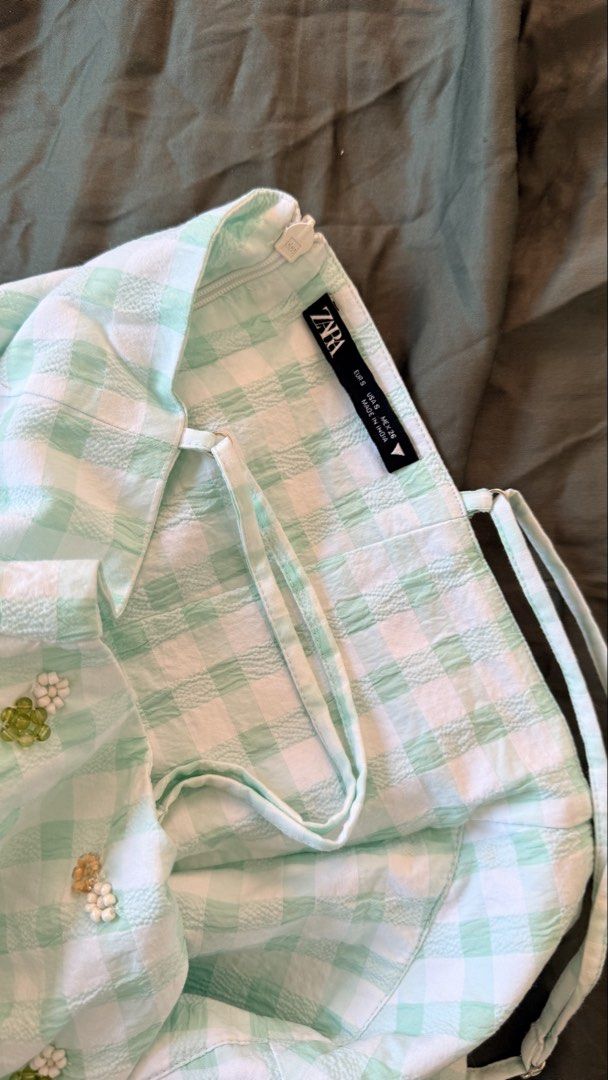 Zara Green Gingham Beaded Mini Dress (Category: Dresses) located in Batangas. Submitted by krieldre (Listing ID 1465776679, Image 3). Description: - Brand: Zara - Size: S - Style: Sleeveless mini dress with flouncy flared skirt and side zipper - Pattern: Green and white gingham seersucker fabric - Details: Cute beaded flower embellishments on the bust and adjustable thin straps - Condition: Excellent, great for warm weather.