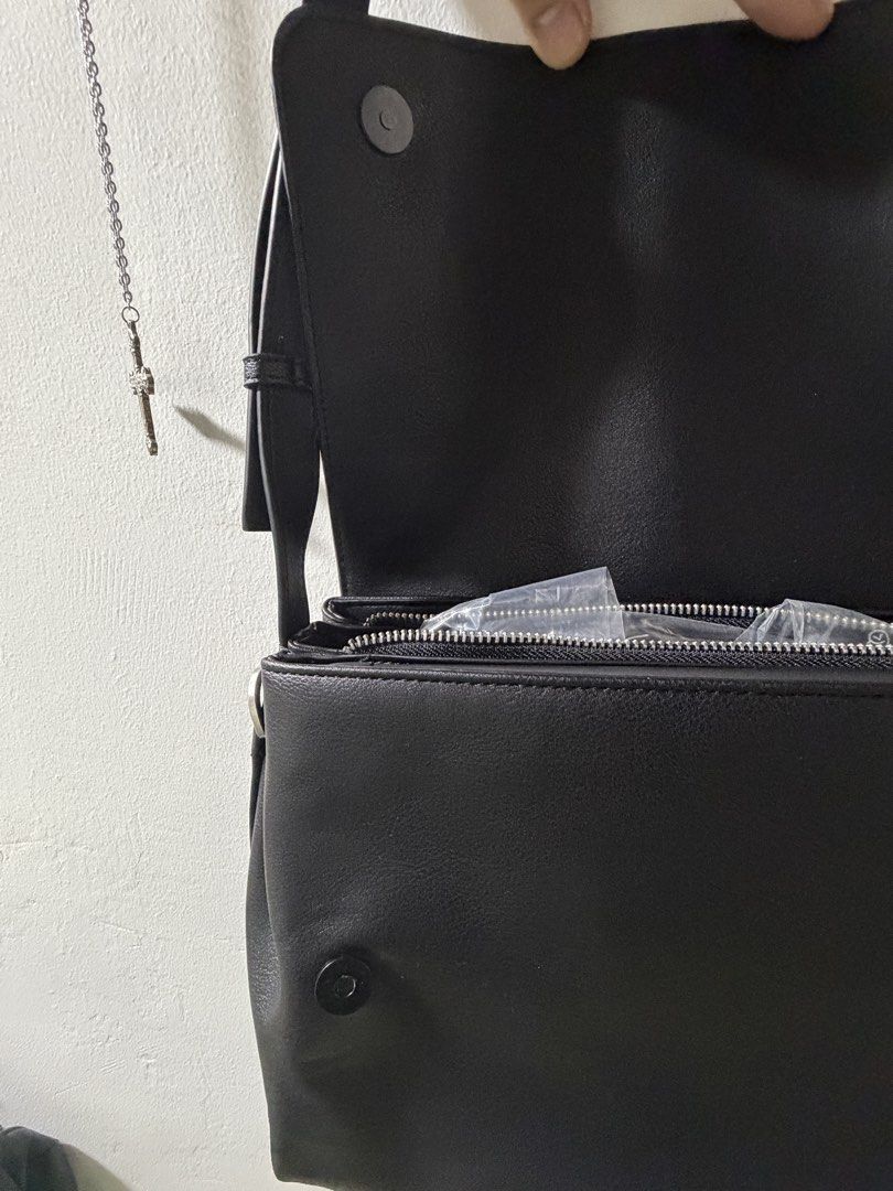 ZARA leather crossbody messenger bag with adjustable strap (Category: Cross-body Bags) located in Manila. Submitted by lowideyn (Listing ID 1465824482, Image 2). Description: - Color & Material: Black faux leather - Closure: Magnetic snap flap with extra top zipper for security - Strap: Adjustable with metal buckle - Capacity: Roomy main compartment fits a standard tablet or iPad - Condition: Clean inside and out, smoke-free home - unused.
