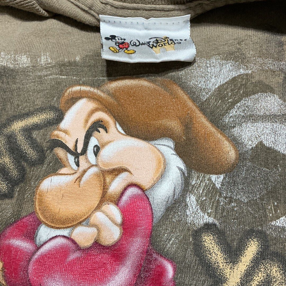 2000s Walt Disney World Grumpy T-Shirt (Category: Shirts) located in Naga. Submitted by lootersfinder (Listing ID 1466024687, Image 3). Description: - Official Walt Disney World vintage graphic tee - Features Grumpy from Snow White with the bold quote: "I'm right you're wrong any questions?" - Color: Classic brown with a crew neck and short sleeves - Condition: Noticeable staining on the front lower portion (priced accordingly) - Tagged with offi