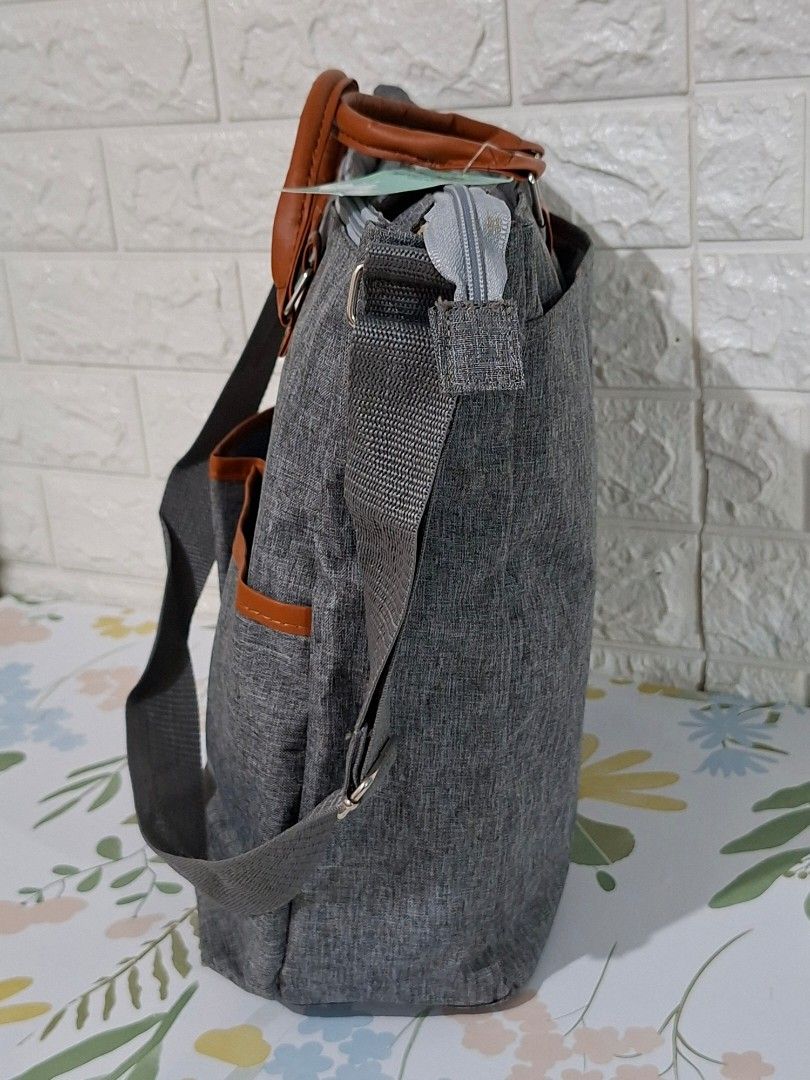 👶👜 Stylish Gray Diaper Bag (Category: Diaper Bags & Wetbags) located in Taguig. Submitted by authprelovedonlineshop2 (Listing ID 1466007881, Image 3). Description: ### 👶👜 Stylish Gray Diaper Bag **Brand New! ✨** Unused! - Elegant **gray diaper bag** with brown leather accents - Spacious interior with **multiple compartments** - Includes **shoulder strap & top handles** - Secure **zippered closure** - Convenient **exterior pockets** for easy a