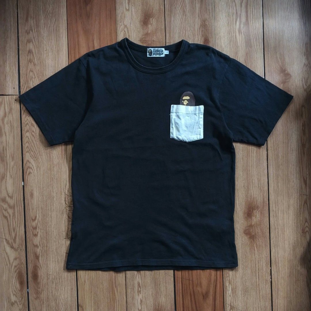 A Bathing Ape BAPE Ape Head Pocket Tee Black Size L (Category: Tshirts & Polo Shirts ) located in Paranaque City. Submitted by thriftine5 (Listing ID 1466011091, Image 1). Description: - Brand: A Bathing Ape (BAPE) - Color: Black - Size: L - Material: 100% Cotton - Design: Crew neck with light camo front pocket and peeking ape head graphic - Tags: World Gone Mad collar tag (1993-2093), Made in China wash tag - Condition: Worn condition with norma