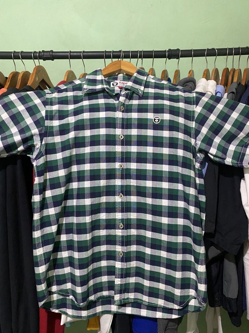 Aape By A Bathing Ape Green Plaid Button-Down Shirt (Category: Tshirts & Polo Shirts ) located in Tiaong. Submitted by maticbuy (Listing ID 1465966058, Image 1). Description: - Brand: Aape by A Bathing Ape - Design: Green and blue plaid short-sleeve shirt - Back Detail: Large white Ape head logo print - Chest Detail: Smaller embroidered logo patch on the pocket area - Closure: Button-down front with branded buttons - Size: L (verified via inner w