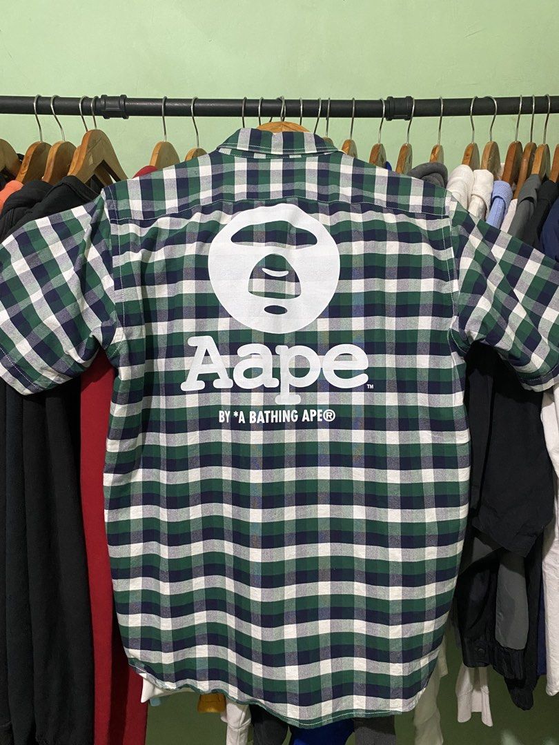 Aape By A Bathing Ape Green Plaid Button-Down Shirt (Category: Tshirts & Polo Shirts ) located in Tiaong. Submitted by maticbuy (Listing ID 1465966058, Image 2). Description: - Brand: Aape by A Bathing Ape - Design: Green and blue plaid short-sleeve shirt - Back Detail: Large white Ape head logo print - Chest Detail: Smaller embroidered logo patch on the pocket area - Closure: Button-down front with branded buttons - Size: L (verified via inner w